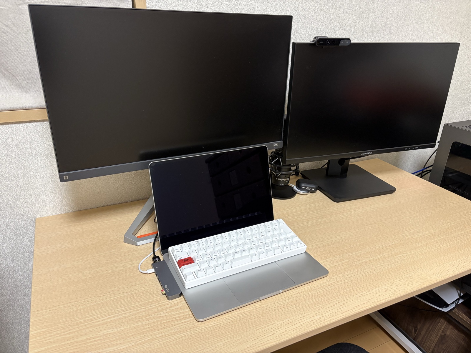 デスクのMacBook Airの手前に置いた白いHHKB。左のキーが赤い30周年記念モデル